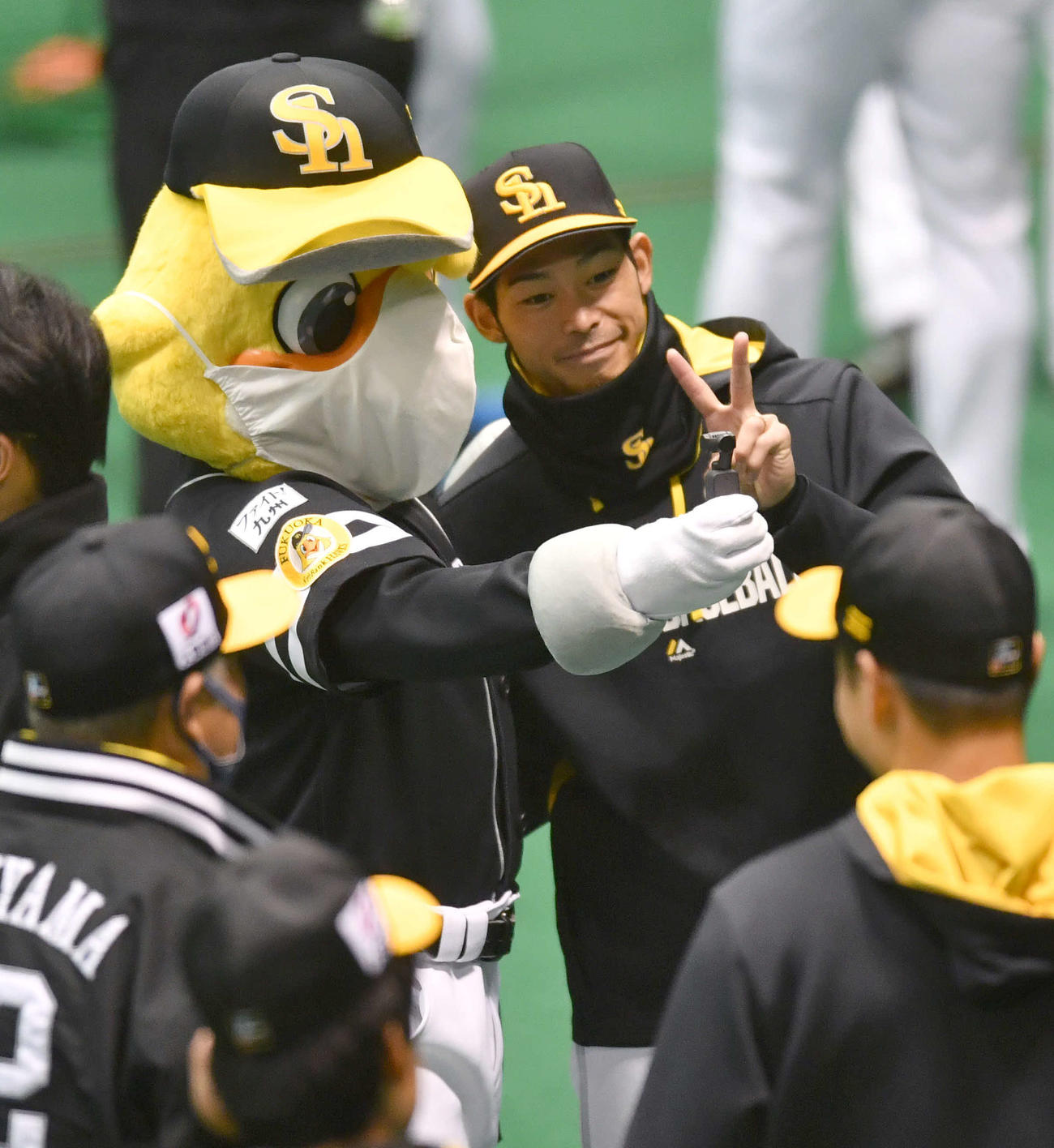 宮崎キャンプに合流し、ハリーホークと記念撮影する又吉（撮影・岩下翔太）
