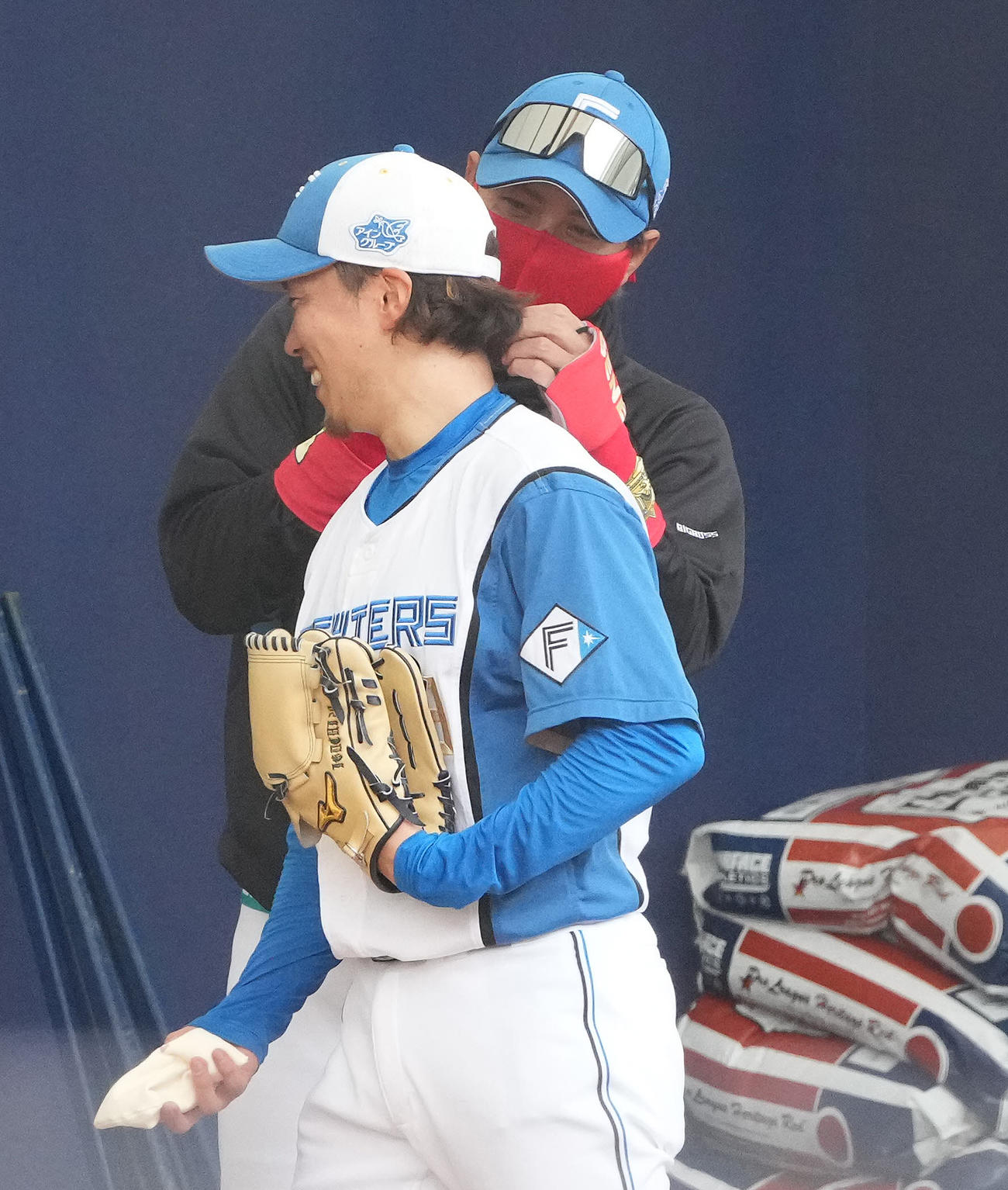 ブルペンで井口（手前）の襟足を気にする日本ハム新庄監督（撮影・鈴木みどり）