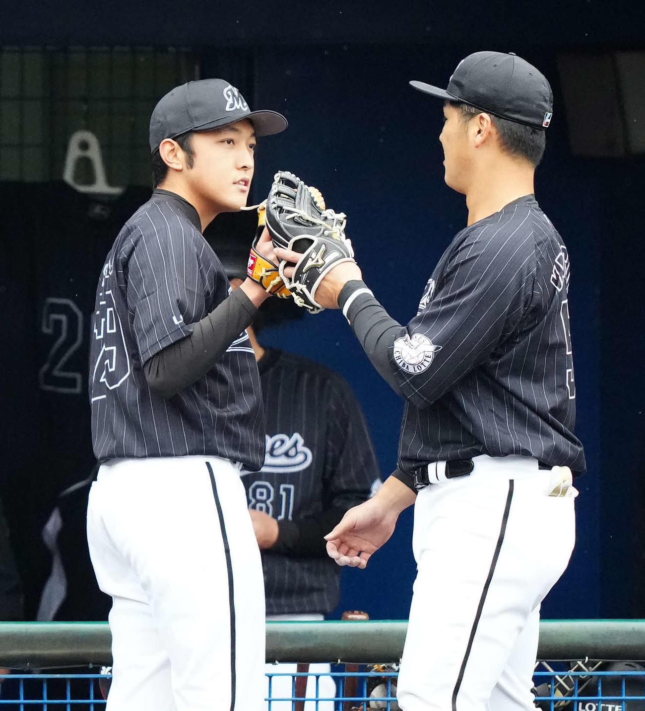 ヤクルト対ロッテ　2回裏終了後、ロッテ山口（右）とタッチをかわす先発の佐藤奨（撮影・江口和貴）