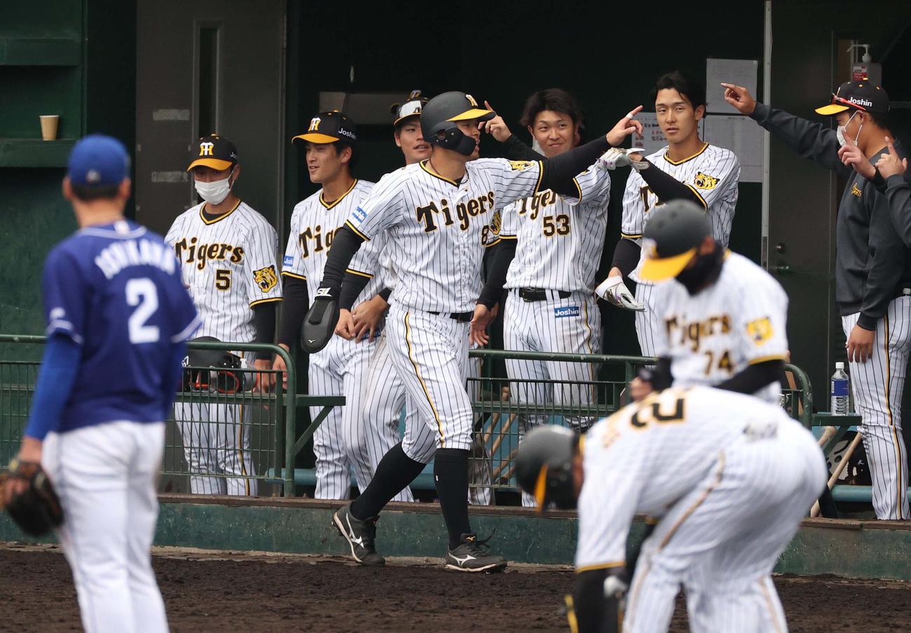 9回裏阪神1死二塁、江越の適時三塁打で生還しナインの出迎えを受ける佐藤輝（撮影・上田博志）