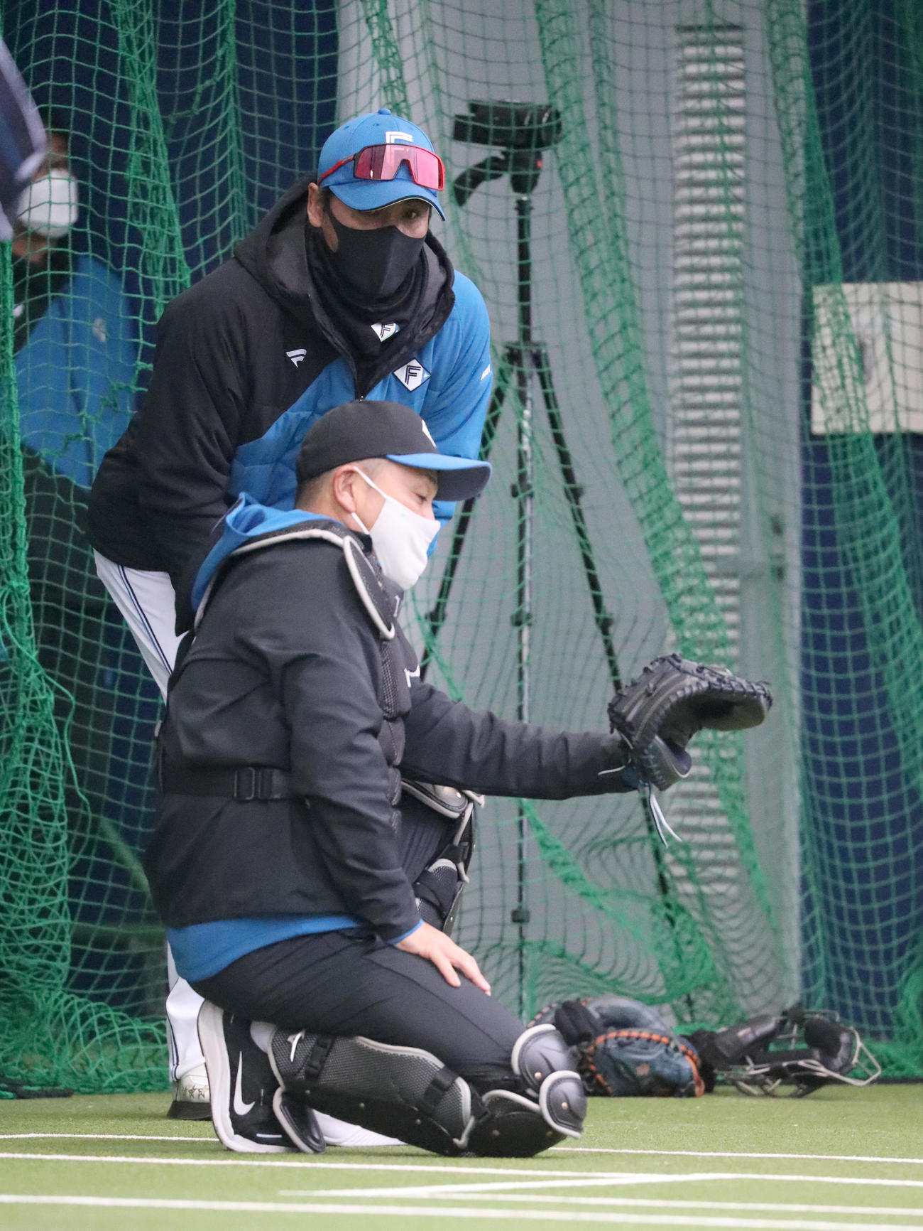 ブルペンで会話をする新庄監督（奥）と谷繁氏（撮影・佐藤翔太）