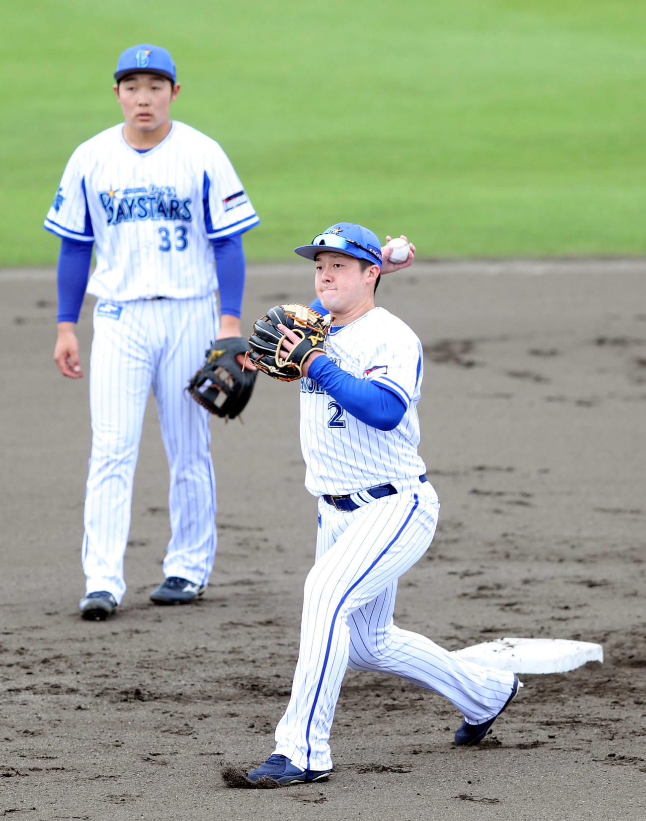 DeNA対沖縄電力　試合前、シートノックで送球する牧（右）。後方は粟飯原（撮影・狩俣裕三）