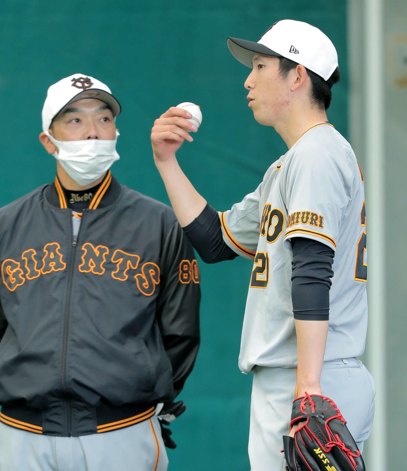 ブルペンで阿部作戦兼ディフェンスチーフコーチ（左）と言葉を交わす巨人戸郷（撮影・河田真司）