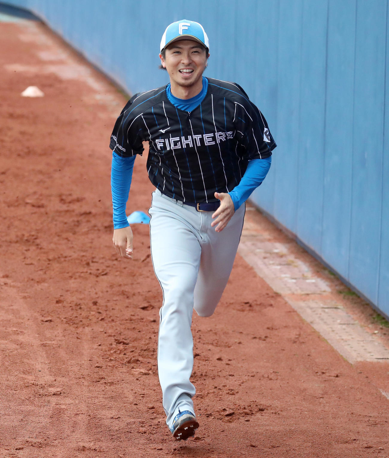 笑顔でダッシュする日本ハム上沢（撮影・佐藤翔太）