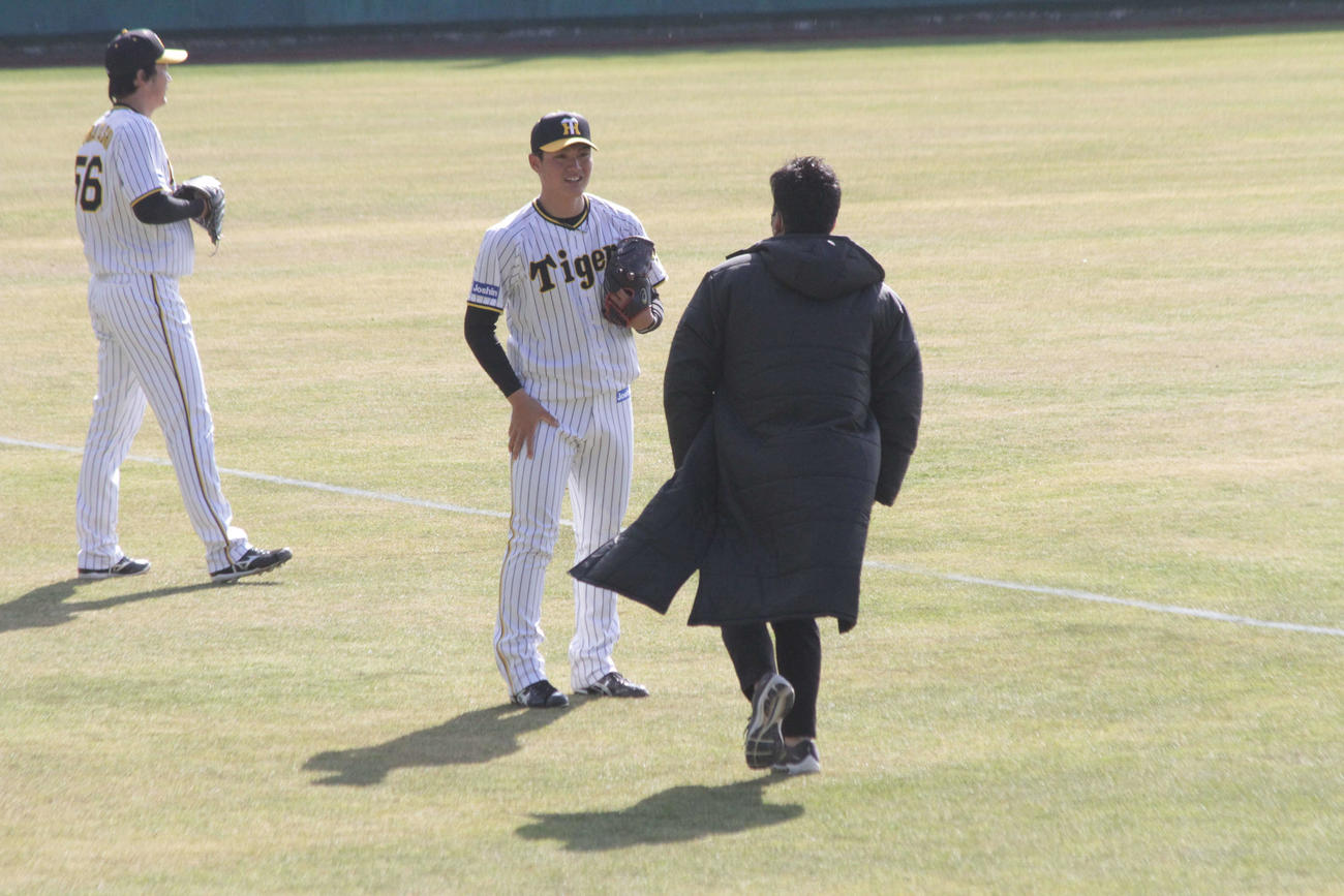 阪神藤川SA（右）はキャッチボールを行う西純に片足で立って助言する