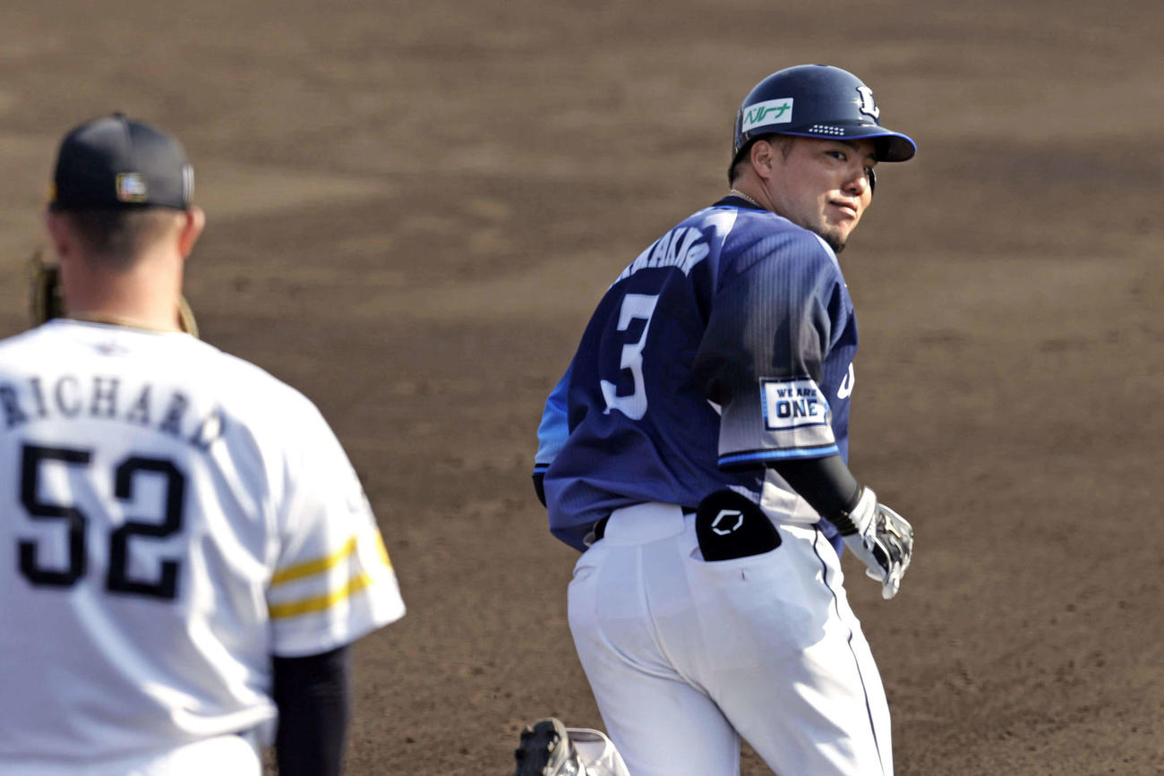 ソフトバンク対西武　7回表西武無死一塁、左越え2点本塁打を放った山川（右）は、一塁を回った際に一塁手のリチャードに視線を送る（共同）