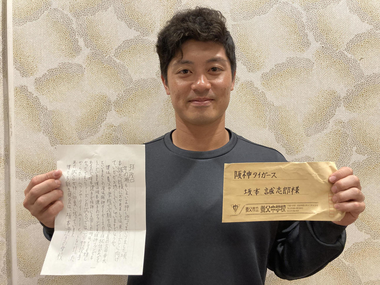 兵庫県養父市立養父中学校の生徒会が主催するオンライン講演会に参加し手紙を手にする坂本（球団提供）