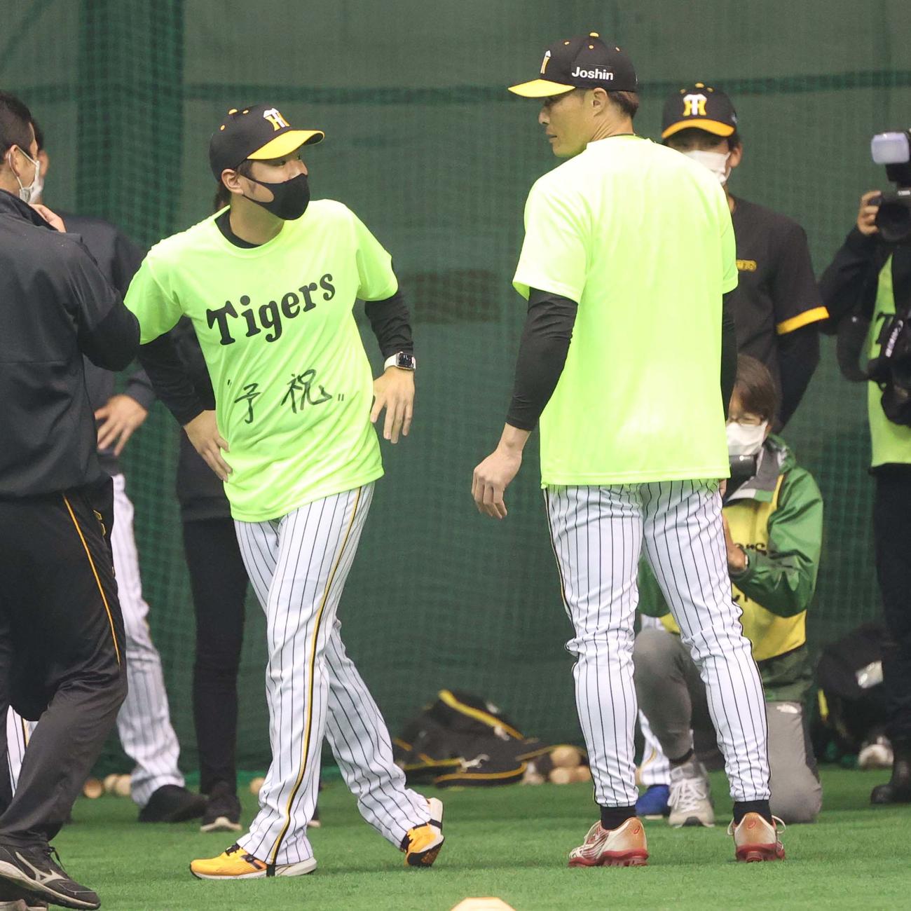 1日主将の西勇（左）は「予祝」Tシャツを着る（撮影・上田博志）