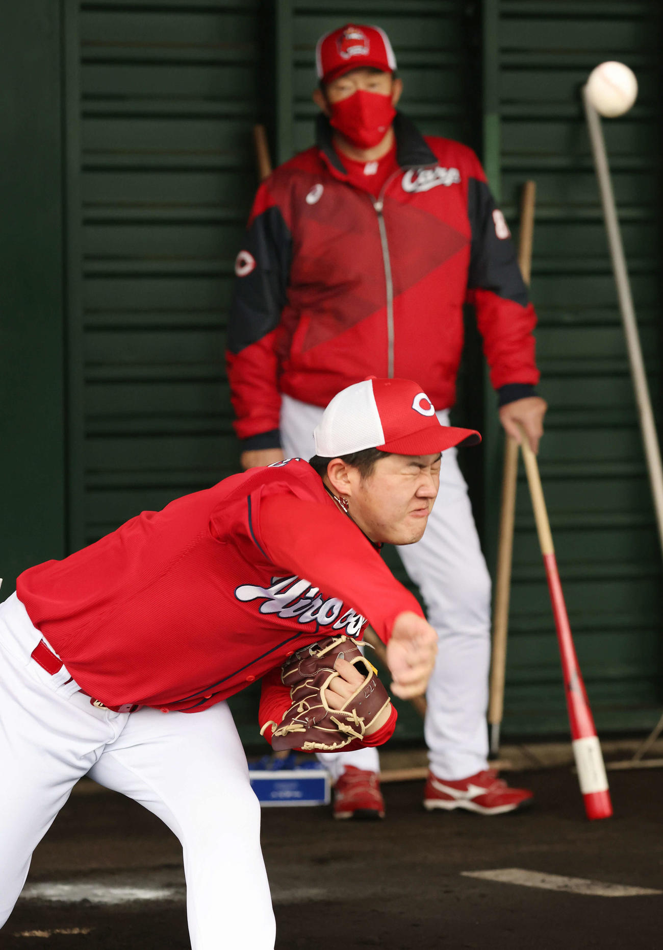 ブルペンで投げる広島ドラフト5位の松本と投球を見守る佐々岡監督（撮影・加藤孝規）