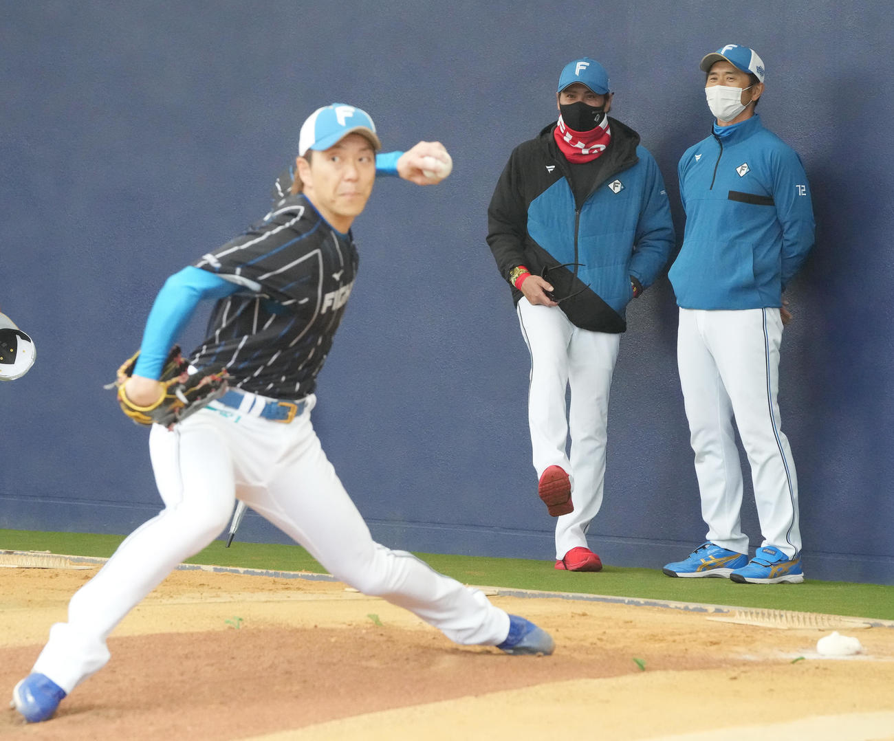 ブルペン投球をする宮西（左）を見守る日本ハム新庄監督。右は山田バッテリーコーチ（撮影・鈴木みどり）
