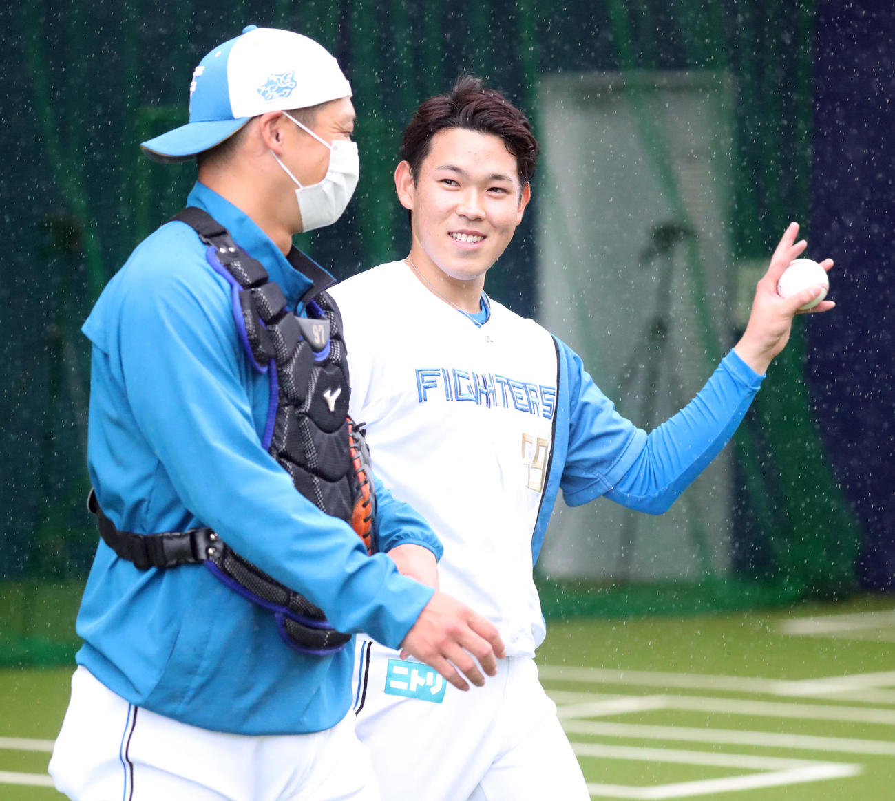 ブルペンでの投球を終え笑顔で話す日本ハム根本（撮影・佐藤翔太）