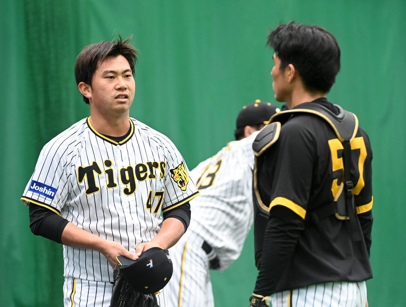 ブルペンで長坂拳弥（右）と話す阪神桐敷拓馬（撮影・前岡正明）