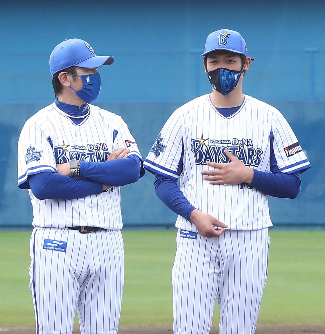 春季キャンプの手締めに臨み、DeNA三浦監督（左）と言葉をかわす小園