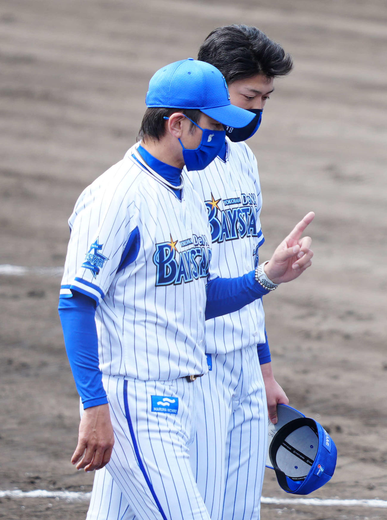 春季キャンプの手締めを終え、DeNA三浦監督（手前）から言葉をかけられる小園（撮影・江口和貴）