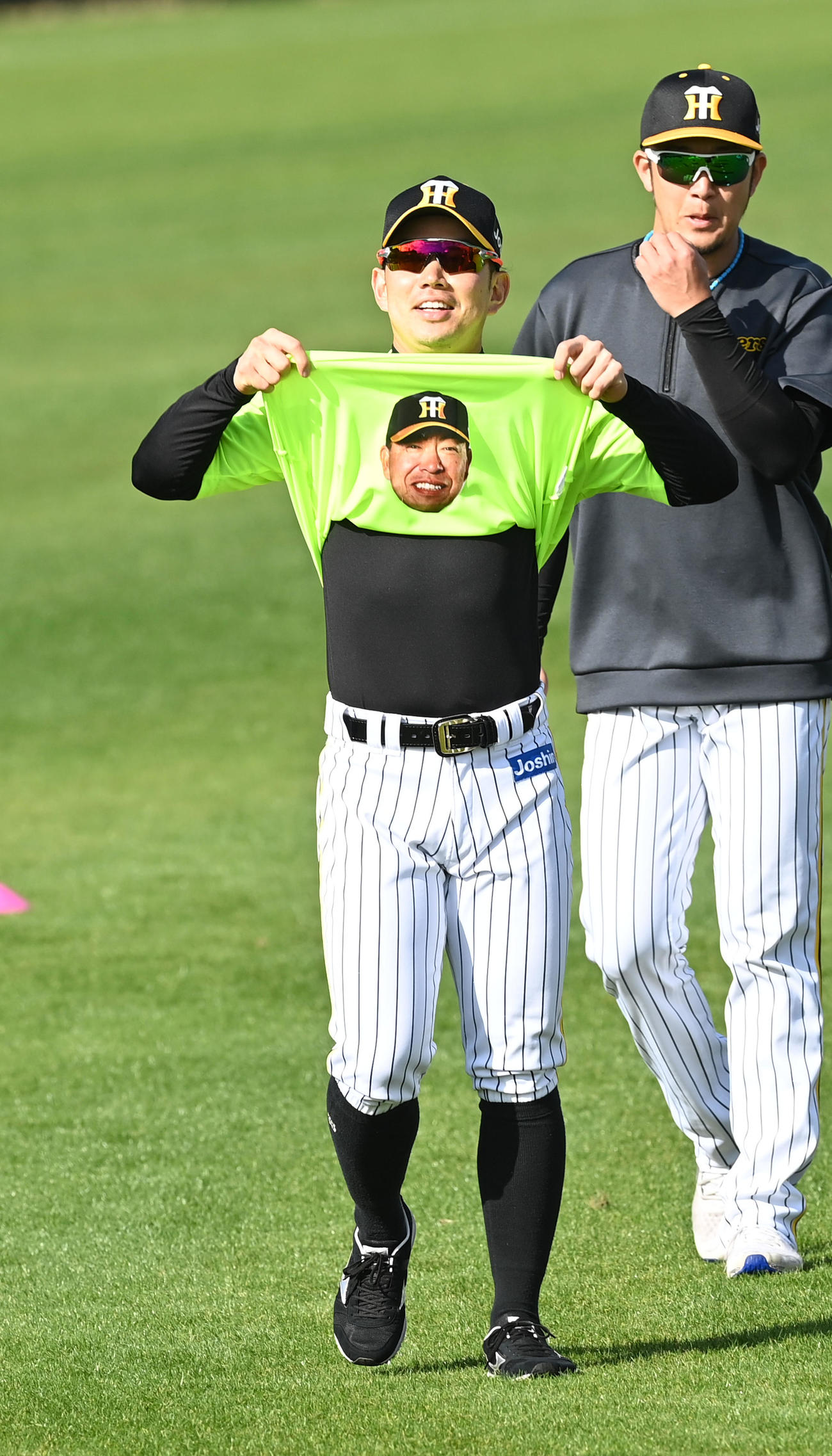 井上ヘッドコーチの顔が入った1日キャプテンのTシャツを着る糸原（撮影・前岡正明）