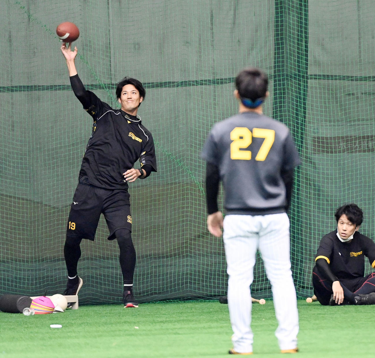 伊藤将（手前）にアメフトのボールを投げる藤浪（撮影・前岡正明）