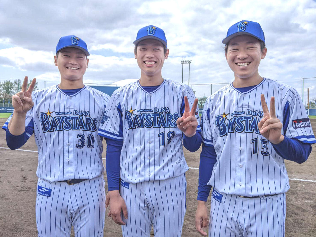 笑顔でピースサインする、左からDeNA三浦、小園、徳山（球団提供）