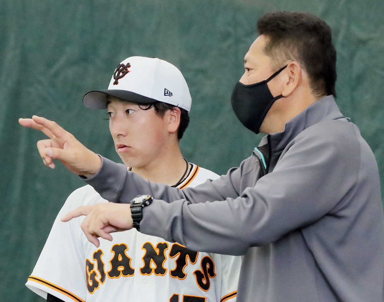 ブルペンで大勢（左）にアドバイスする佐々木氏（撮影・河田真司）