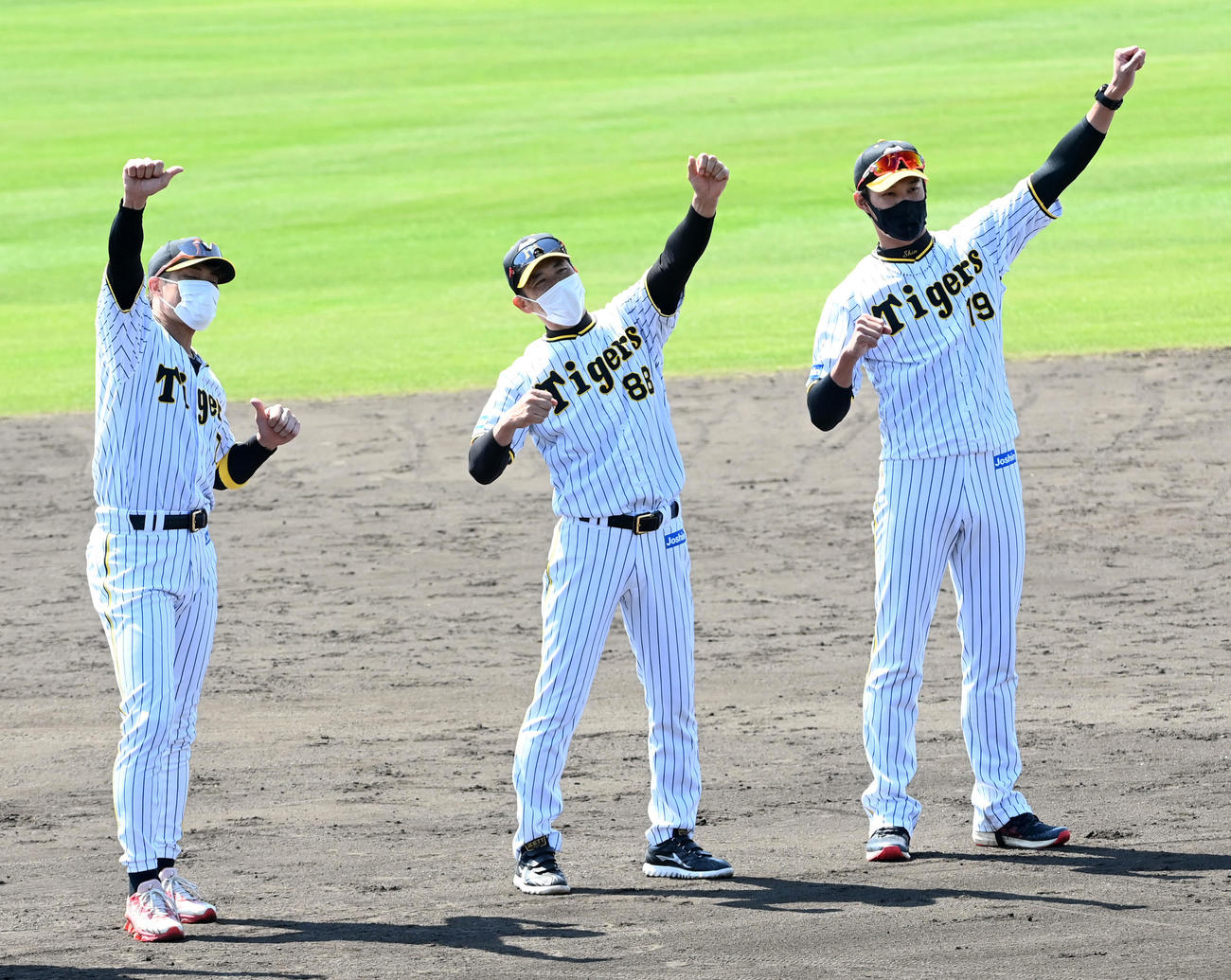 宜野座キャンプを打ち上げ、ラパンパラ締めを行う（左から）阪神糸井、矢野監督、藤浪（撮影・前岡正明）