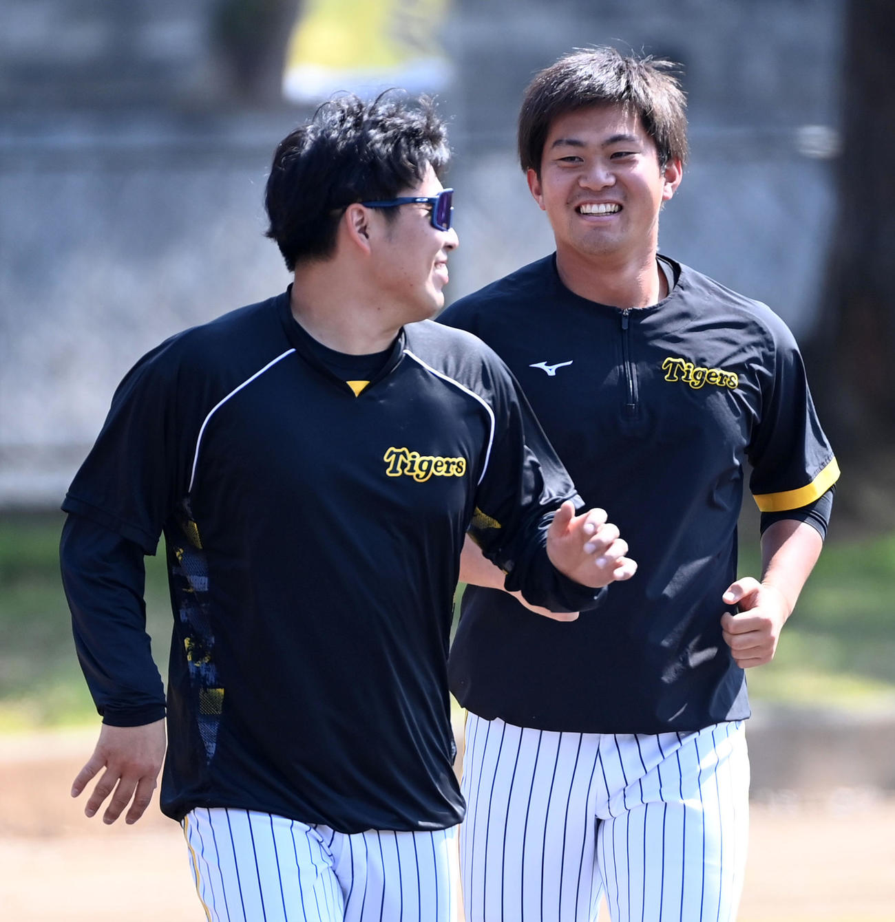 笑顔でサブグラウンドを走る阪神馬場（左）と桐敷（撮影・前岡正明）