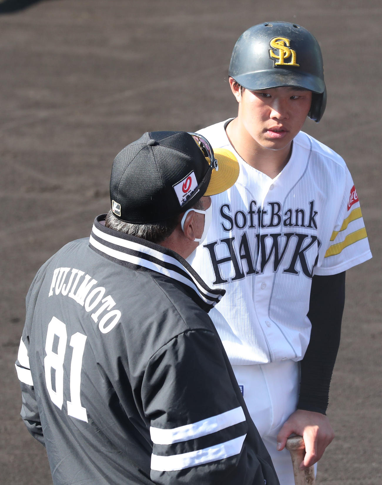 打撃練習前、藤本博史監督と話をする井上朋也（撮影・梅根麻紀）