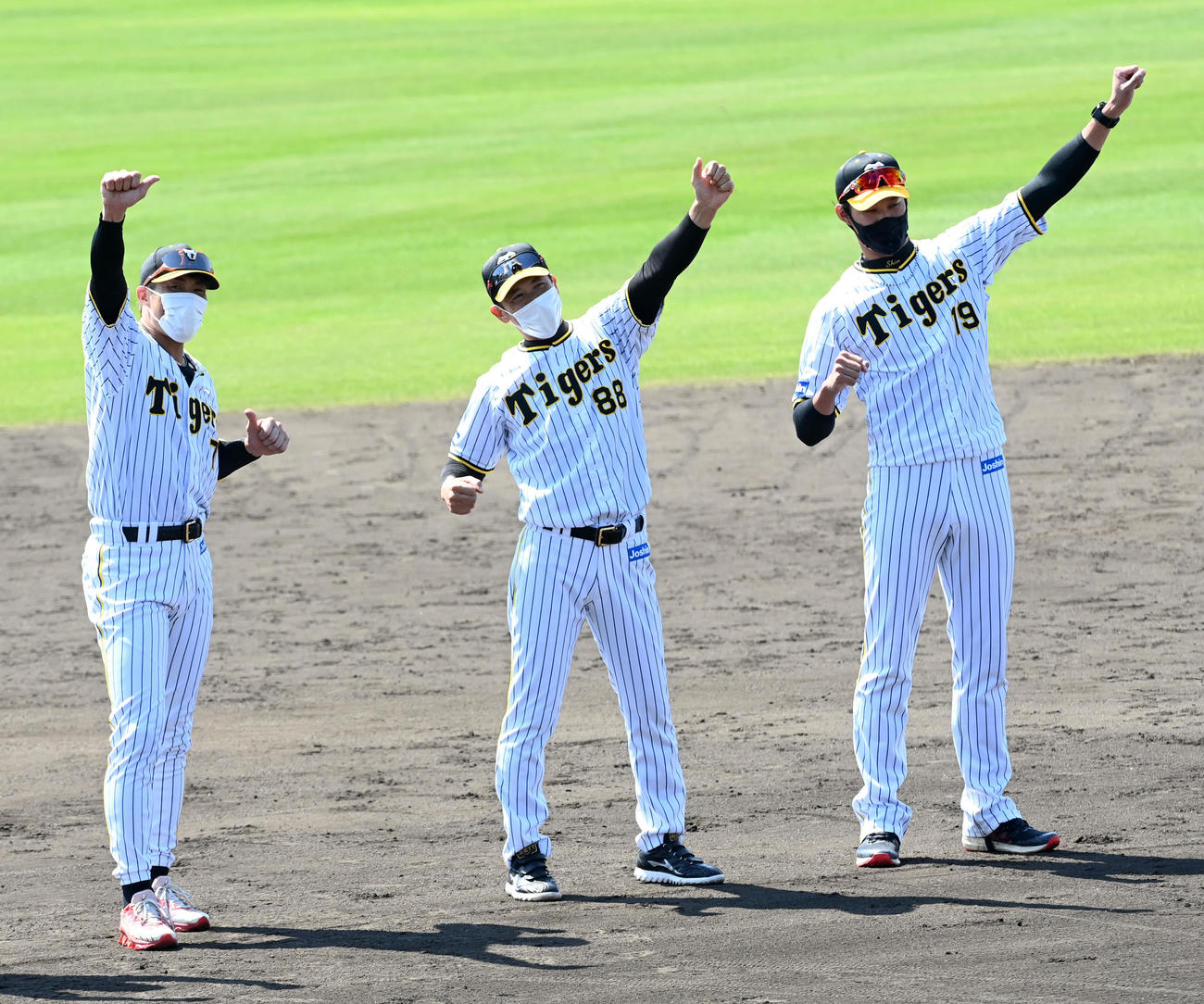 宜野座キャンプを打ち上げ、ラパンパラ締めを行う（左から）阪神糸井、矢野監督、藤浪（撮影・前岡正明）
