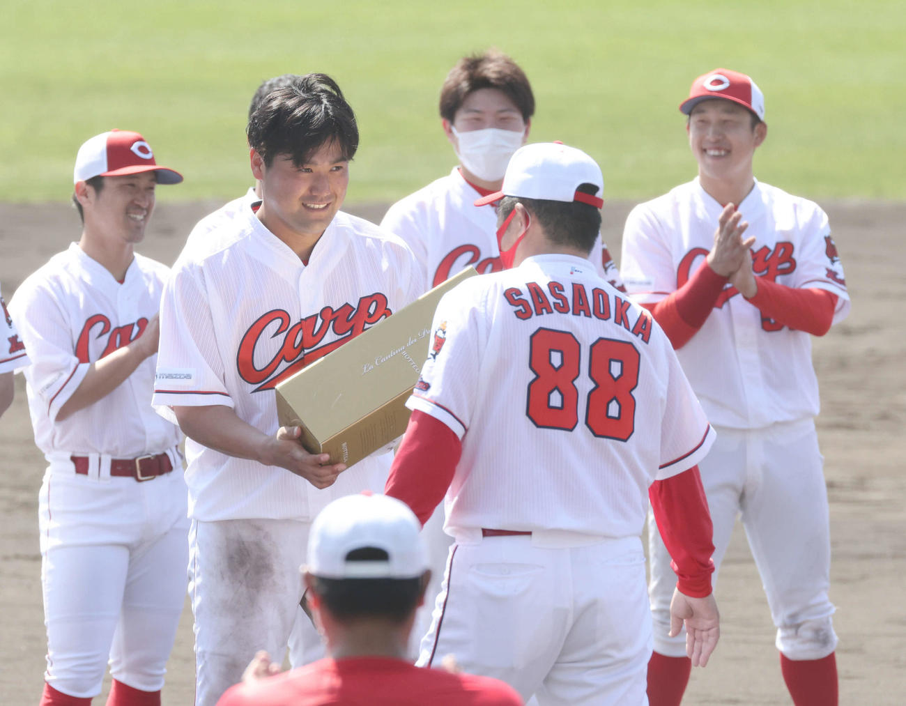 キャンプ打ち上げで佐々岡監督（手前）から表彰される末包（撮影・加藤孝規）