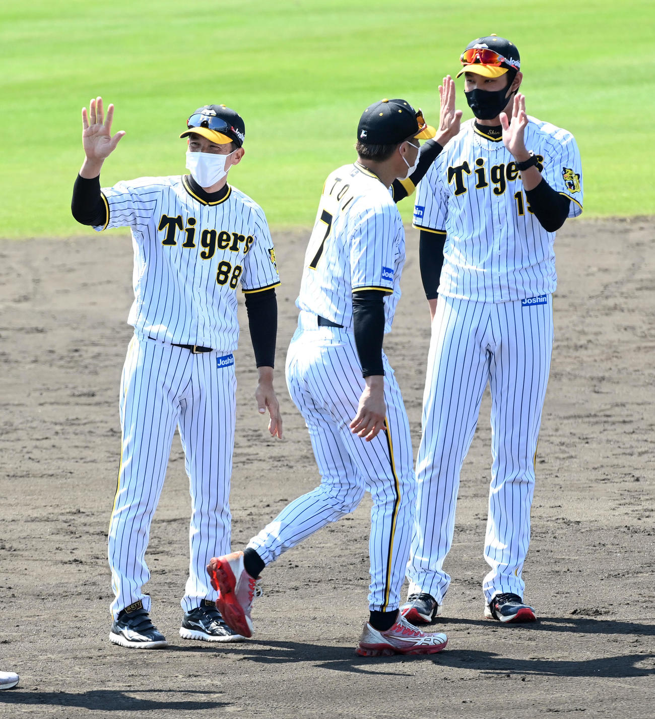 阪神宜野座キャンプを打ち上げ、糸井（中央）とタッチする藤浪（右）。左は矢野監督（撮影・前岡正明）