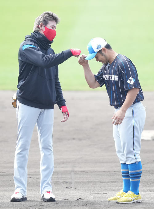 手締め後、近藤（右）とグータッチする日本ハム新庄監督（2022年2月28日撮影）