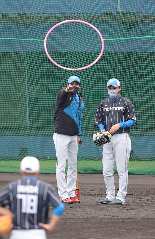 日本ハム金子コーチ（右）にフラフープの間に送球する練習について説明する新庄監督（2022年2月2日撮影）