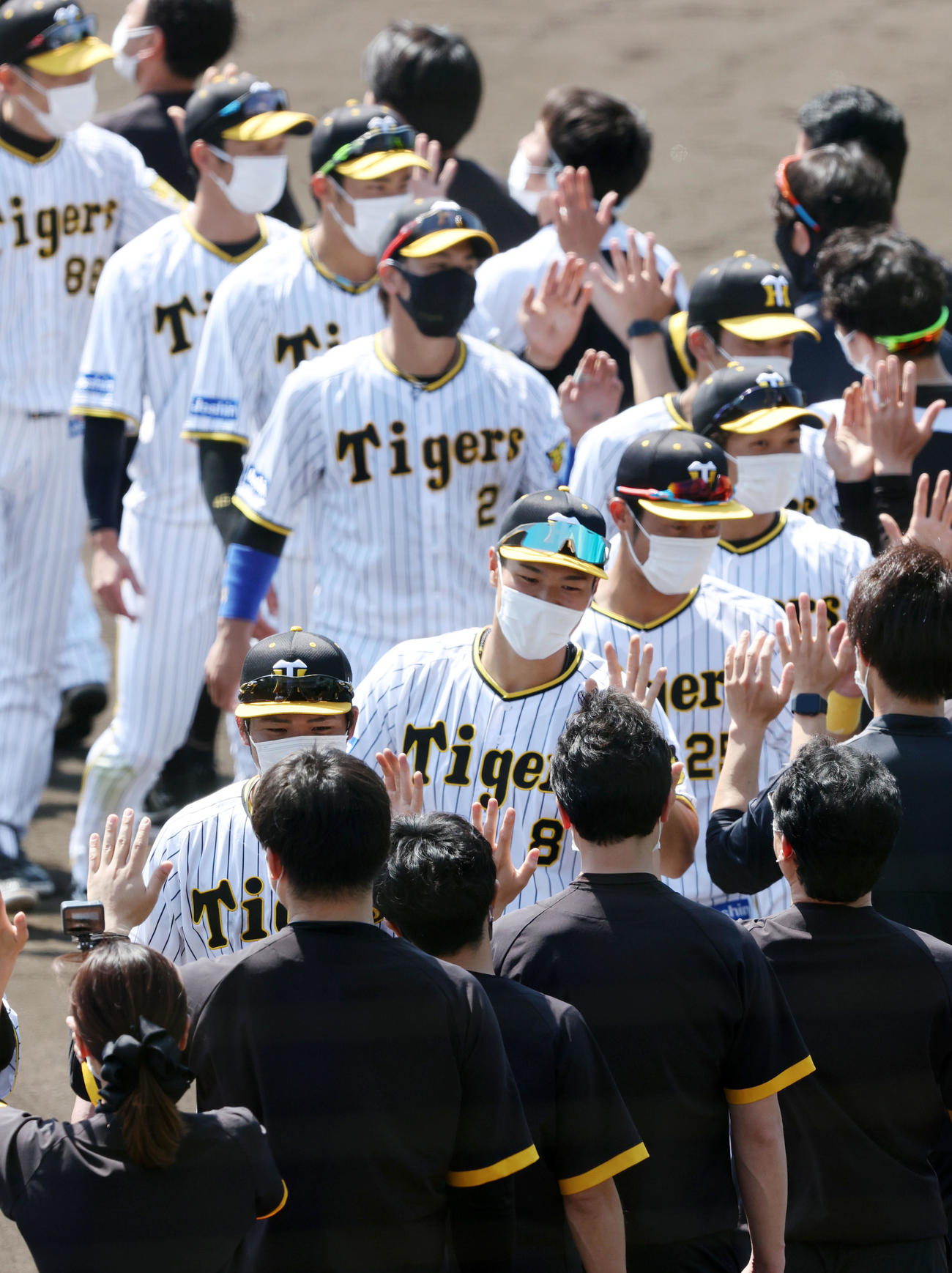キャンプを打ち上げ関係者とタッチする佐藤輝ら阪神ナインたち（撮影・加藤哉）