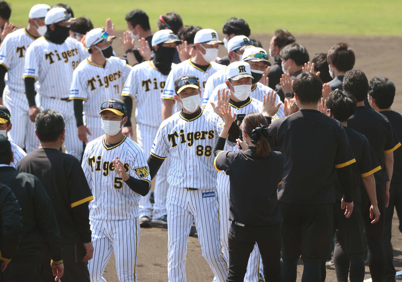 矢野監督（左から3人目）らナインは春季キャンプを終え関係者らとハイタッチする（撮影・上田博志）