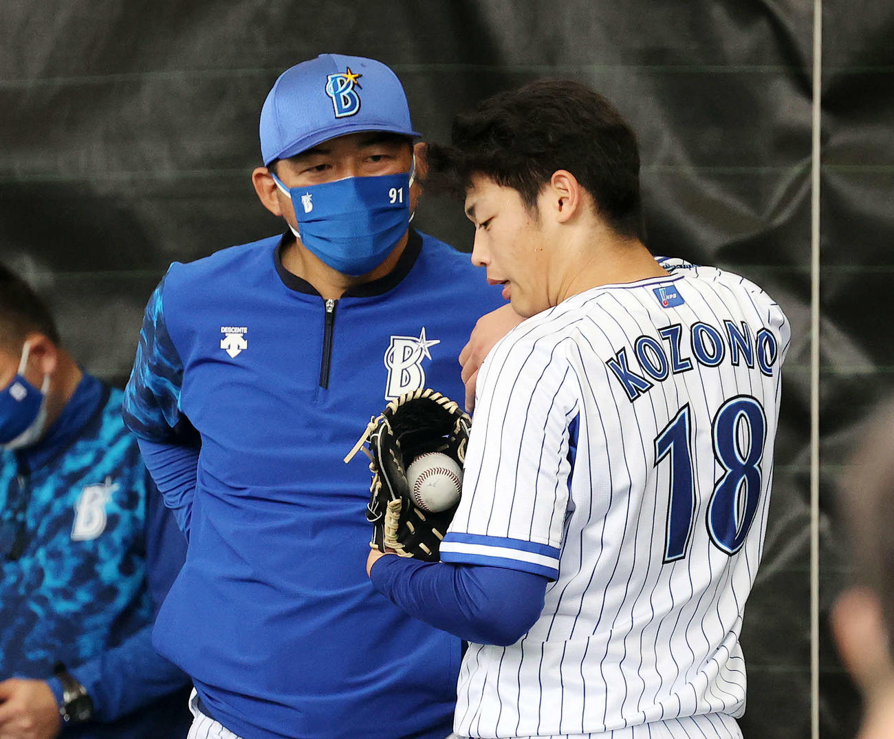 ブルペンで投球練習後、DeNA斎藤投手コーチ（左）と話す小園（2022年2月13日撮影）