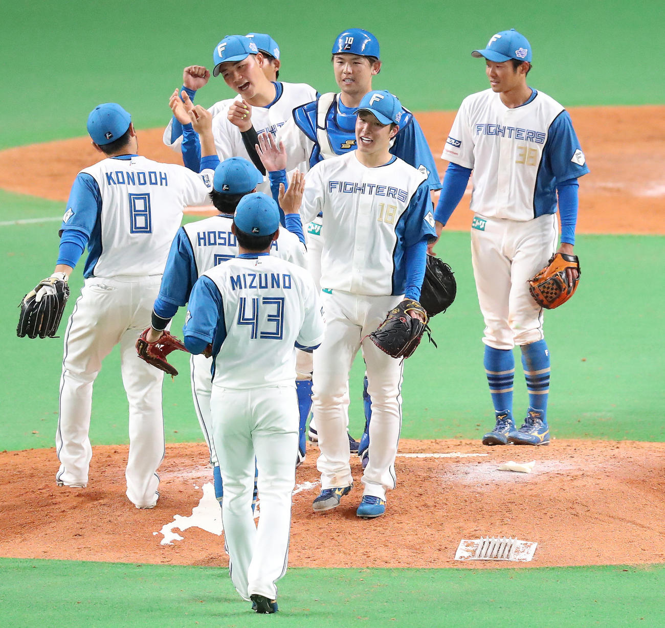 日本ハム対ヤクルト　セーブを挙げてナインと笑顔でタッチを交わす吉田（中央）（撮影・佐藤翔太）