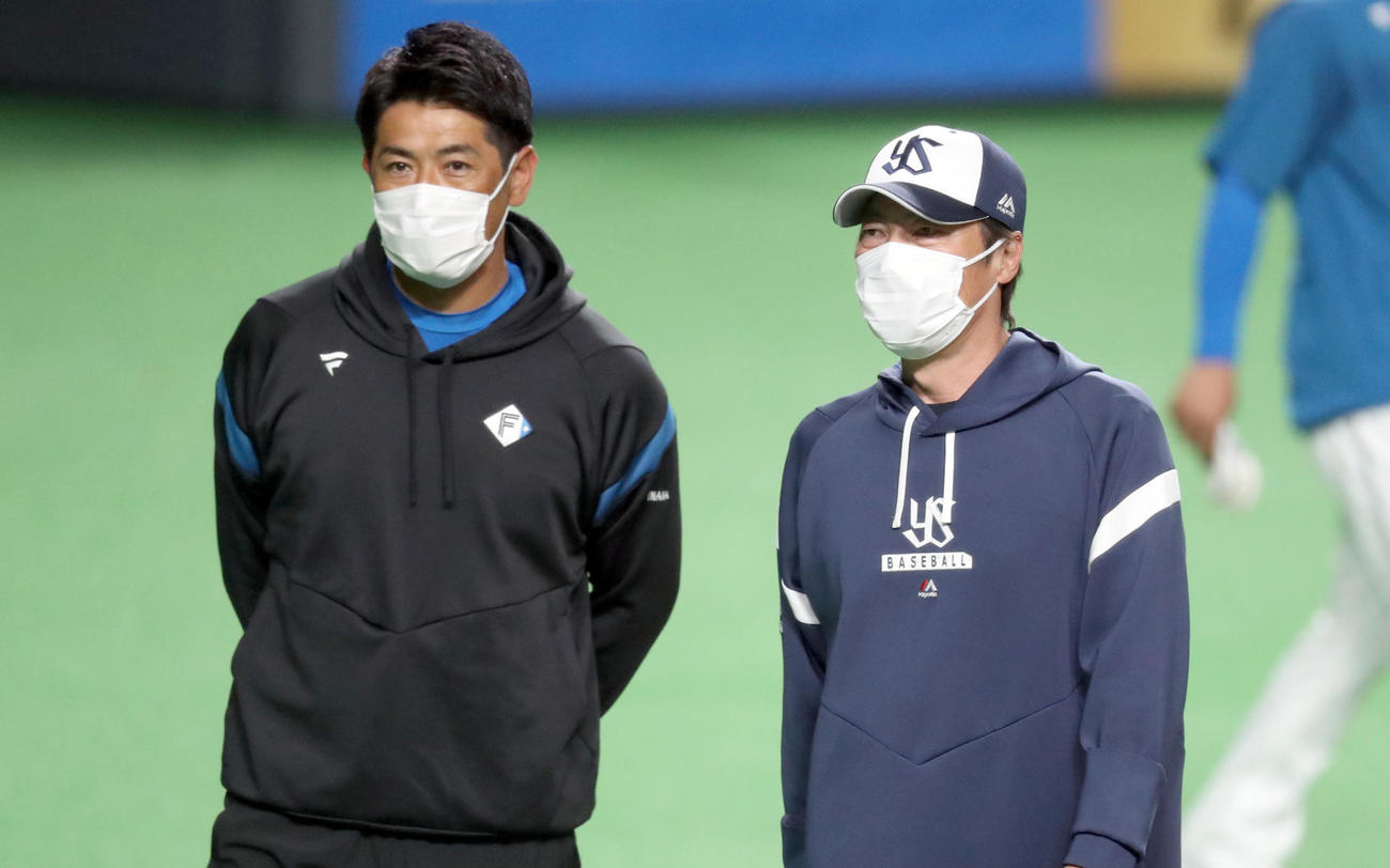日本ハム対ヤクルト　試合前、会話をする日本ハム稲葉GM（左）とヤクルト高津監督（撮影・佐藤翔太）