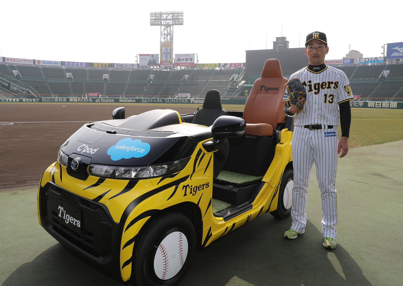 今季から使用されるリリーフカーとポーズを決める阪神岩崎（撮影・前田充）