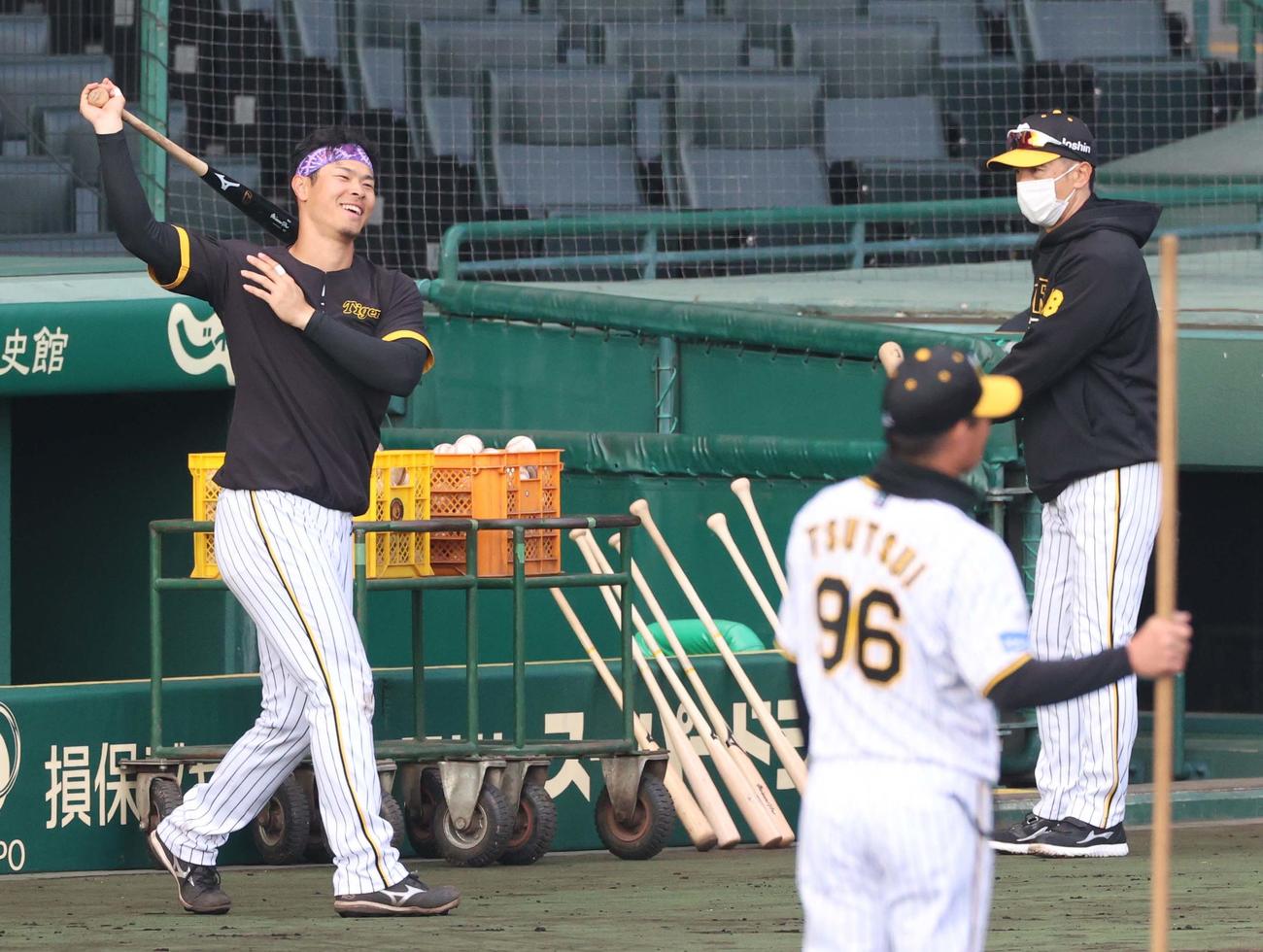 ベンチ前で素振りする佐藤輝（左）は矢野監督の声掛けに笑顔を見せる（撮影・上田博志）