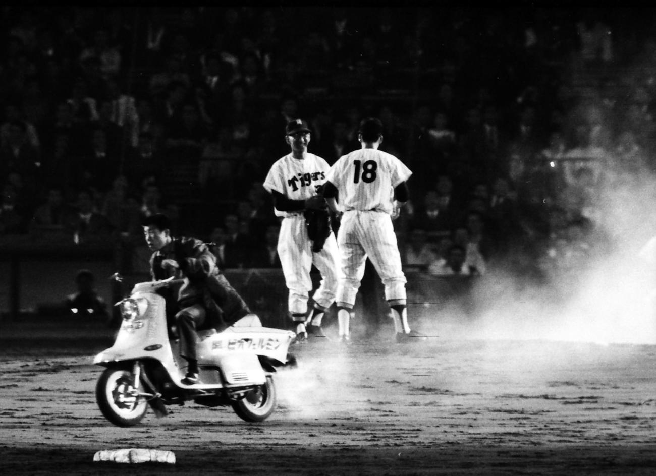 64年、中井悦雄（背番号18）をマウンドに届け、白煙を上げながら引き返すリリーフバイク