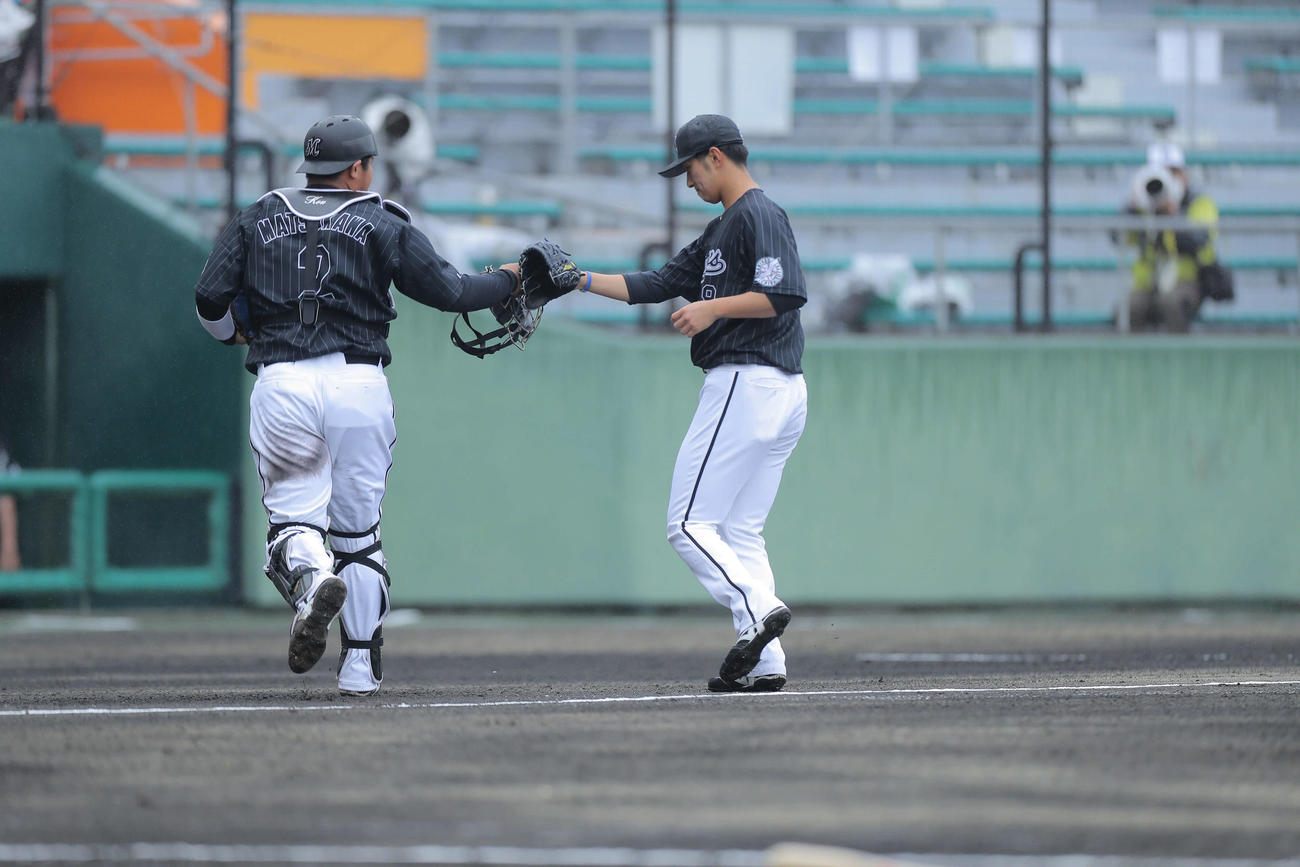 タッチを交わす松川虎生（左）と本前郁也（22年2月17日撮影）