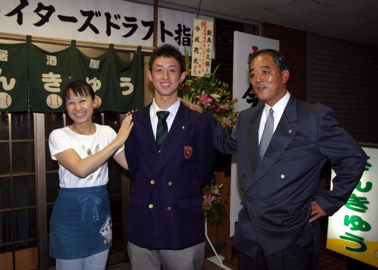 日本ハムに4巡目指名された浦和学院の今成亮太（中央）は、父の泰章スカウト（右）と母康子さんに自宅の居酒屋前で祝福される（2005年10月3日撮影）