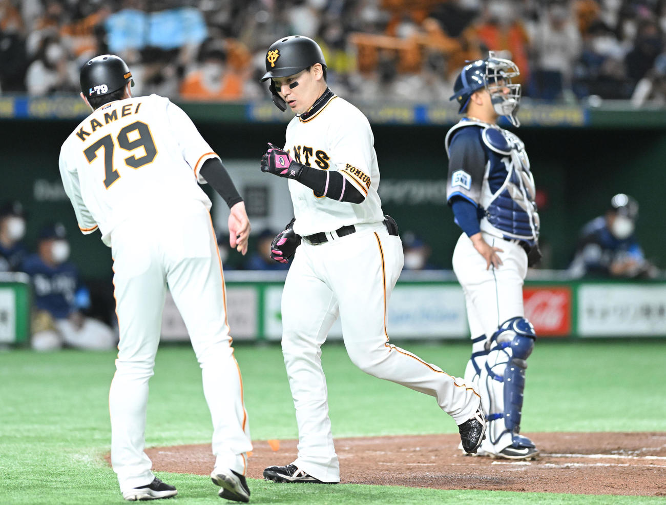巨人対西武　1回裏巨人無死、先制の左越えソロ本塁打を放った丸（中央）は生還し亀井コーチとタッチを交わす。捕手森（撮影・滝沢徹郎）