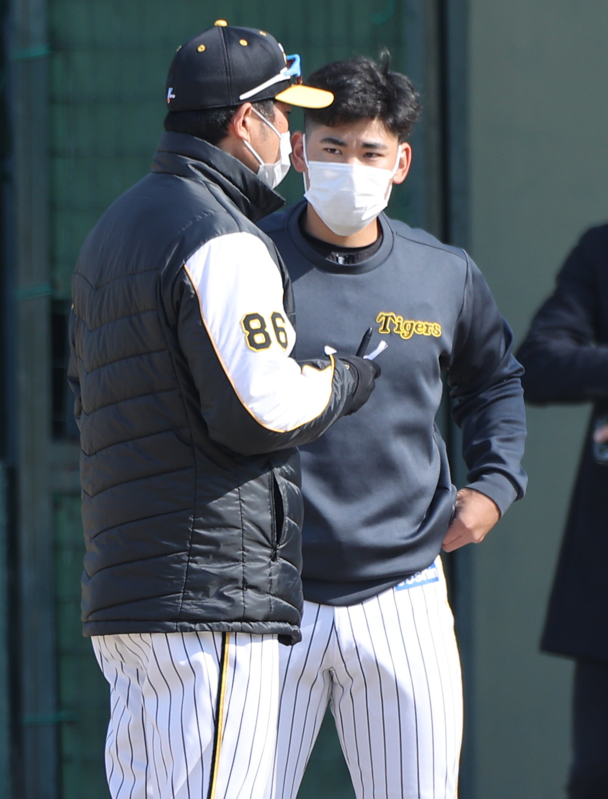 鳴尾浜球場で阪神安藤2軍育成コーチ（左）の話を聞く阪神鈴木（撮影・上山淳一）