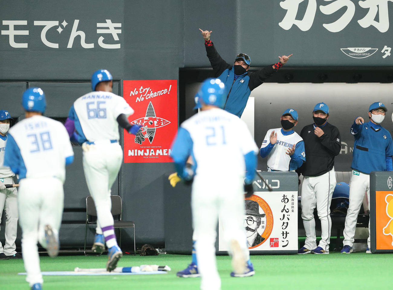 日本ハム対ソフトバンク　1回裏日本ハム2死一、三塁、左越え3点本塁打を放った万波（左から3人目）を笑顔で出迎える新庄監督（中央後方）（撮影・佐藤翔太）