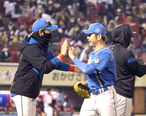 3安打90球で完封勝利を挙げた日本ハム加藤(右)は新庄監督に出迎えられる(撮影・黒川智章)
