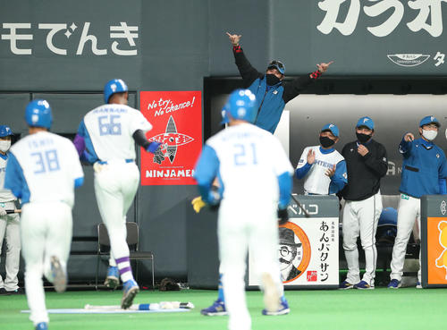 日本ハム対ソフトバンク 1回裏日本ハム2死一、三塁、左越え3点本塁打を放った万波(左から3人目)を笑顔で出迎える新庄監督(中央後方)(撮影・佐藤翔太)