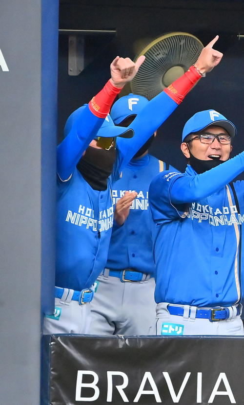 オリックス対日本ハム 中堅手松本剛の補殺に両手を突き上げ喜ぶ新庄監督(左)(撮影・和賀正仁)