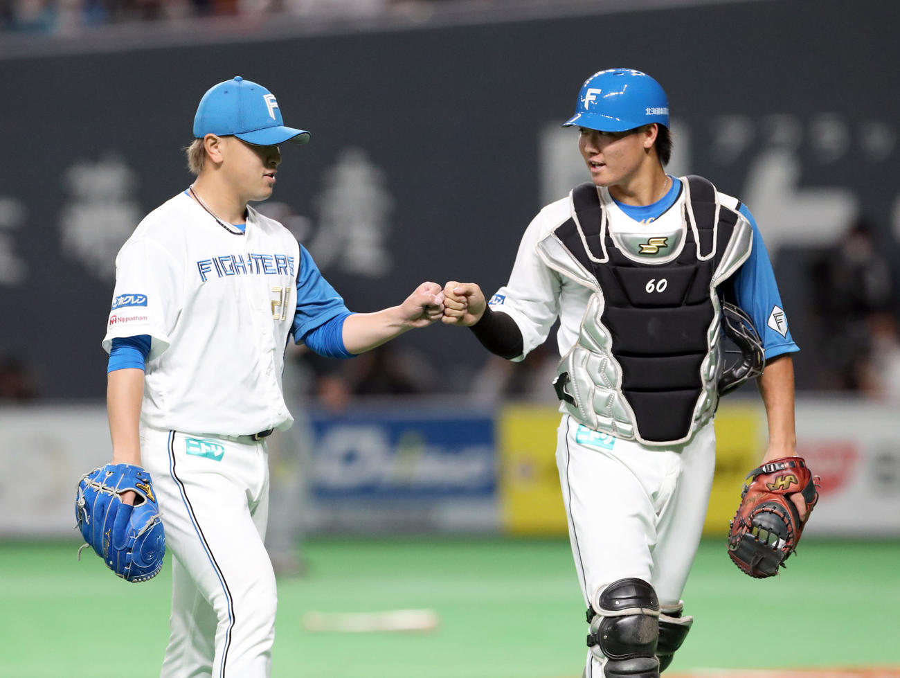日本ハム対巨人　グータッチを交わしながらベンチに戻る日本ハム河野（左）と郡（撮影・佐藤翔太）