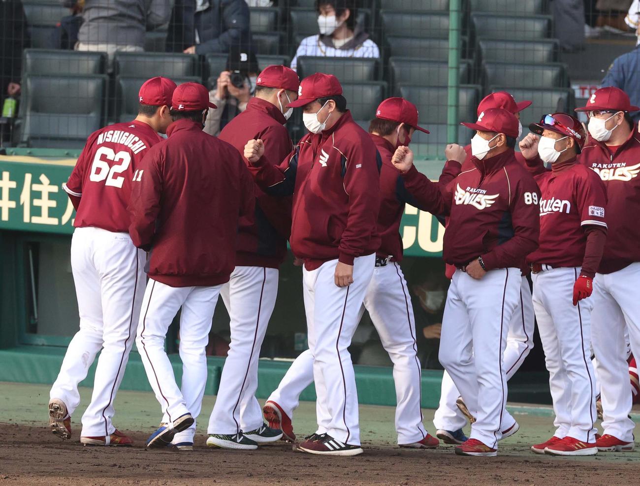 阪神対楽天オープン戦　阪神に勝利した石井監督（左から4人目）は先発岸（左から2人目）とグータッチする（撮影・上田博志）