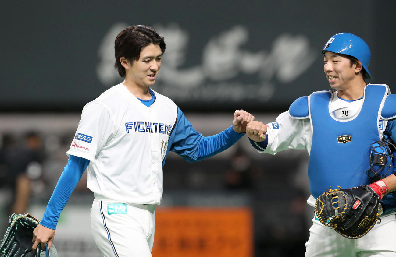 タッチを交わしながらベンチに戻る日本ハム上沢（左）と宇佐見（撮影・佐藤翔太）