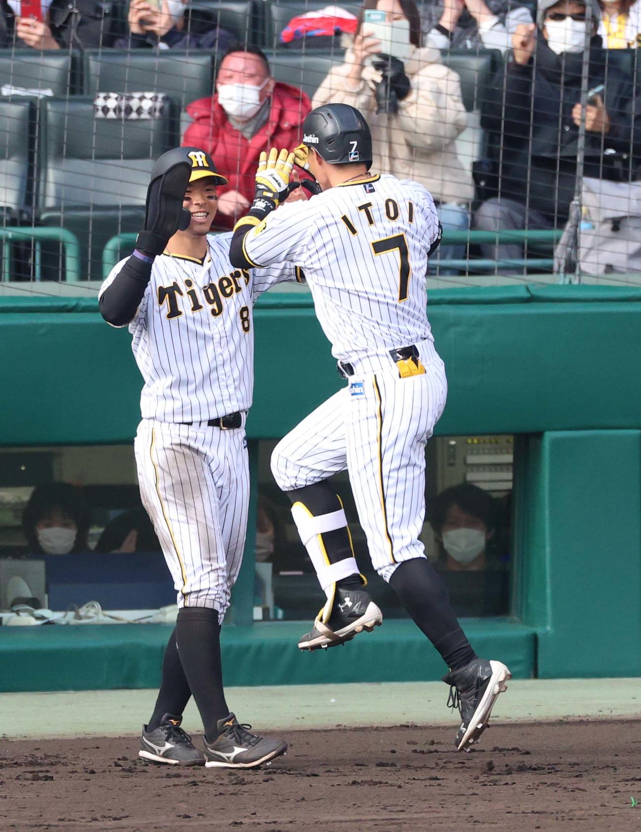 阪神対楽天オープン戦　4回裏阪神1死二塁、中越え2点本塁打を放った糸井（右）を笑顔で出迎える佐藤輝（撮影・上田博志）